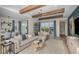 Spacious living room with a modern sectional sofa, stylish decor, and views of the outdoor living space and pool at 1688 Lugano Cir, Nokomis, FL 34275
