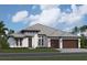 A charming single-story home featuring a light exterior, two-car garage, and meticulously manicured landscaping at 18534 Foxtail Loop, Venice, FL 34293