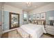 Beautifully staged bedroom with soft blue walls, stylish furnishings, and natural light streaming through the window at 200 Vistera Blvd, North Venice, FL 34275