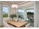 Bright dining area features a large table, modern chandelier, and sliding glass doors to an outdoor patio at 200 Vistera Blvd, North Venice, FL 34275