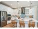 Modern kitchen features white cabinets, stainless appliances, center island with seating, and decorative pendant lighting at 200 Vistera Blvd, North Venice, FL 34275