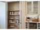 Organized pantry with wooden shelves, wire baskets, and a built-in wine cooler and drink cabinet at 200 Vistera Blvd, North Venice, FL 34275