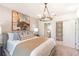 Bright bedroom showcases stylish decor, textured wallpaper, and a decorative chandelier at 2046 Sunset Preserve Way, Port Charlotte, FL 33953