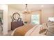 Sunlit bedroom with wooden dresser, decorative mirror, and comfortable furnishings at 2046 Sunset Preserve Way, Port Charlotte, FL 33953