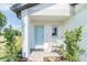 Charming front porch with a light blue door, comfortable seating, and decorative plants at 2046 Sunset Preserve Way, Port Charlotte, FL 33953