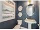 Elegant powder room with patterned wallpaper, pedestal sink, and decorative mirror at 236 Vistera Blvd, Nokomis, FL 34275