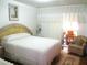A bedroom with white linen, an adjacent sunroom and a sitting area at 4154 57Th N St # 272, Kenneth City, FL 33709