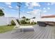 Backyard with deck, patio, lounge chairs, grill, and tropical landscaping at 567 Whippoorwill Dr, Venice, FL 34293