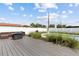 A backyard deck features a modern outdoor sofa, a dark fire pit, and ornamental grass landscaping around a rectangular pool at 567 Whippoorwill Dr, Venice, FL 34293