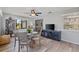 Bright dining area features wood floors, a ceiling fan, and a view of the lush outdoor landscape at 567 Whippoorwill Dr, Venice, FL 34293