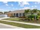 Charming single-story home featuring arched windows, a manicured lawn, and lush landscaping at 567 Whippoorwill Dr, Venice, FL 34293