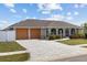 Inviting home featuring a long paved driveway leading to a two-car garage and pristine landscaping at 567 Whippoorwill Dr, Venice, FL 34293