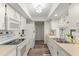 Bright, galley-style kitchen with white appliances, ample counter space, and wood-look flooring at 567 Whippoorwill Dr, Venice, FL 34293