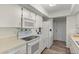 Bright kitchen featuring white cabinets, appliances, and wood-look flooring at 567 Whippoorwill Dr, Venice, FL 34293