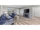 Comfortable living room featuring wood-look laminate floors, a fireplace, and stylish blue sofas at 567 Whippoorwill Dr, Venice, FL 34293