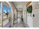 Enclosed front porch featuring tiled floors, white arched openings, and a ceiling fan at 567 Whippoorwill Dr, Venice, FL 34293
