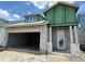 Unfinished house exterior showing open garage and front door entry under blue skies at 7963 Chandler Lake Ct, Hudson, FL 34667