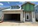 Unfinished house exterior showing open garage and front door entry under blue skies at 7963 Chandler Lake Ct, Hudson, FL 34667