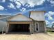 An unfinished single Gathering home showing exterior elevation of the construction with an open garage at 7979 Chandler Lake Ct, Hudson, FL 34667