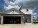 Unfinished new construction home featuring block construction, modern door, and an attached garage at 7979 Chandler Lake Ct, Hudson, FL 34667
