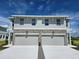 Charming townhome featuring a stone facade, two-car garage, and a well-manicured lawn at 13904 Emerald Fields Dr, Hudson, FL 34667