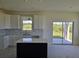 Modern kitchen with white cabinets, quartz countertops, and a black kitchen island at 13904 Emerald Fields Dr, Hudson, FL 34667