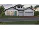 Charming single-story home featuring a two-car garage, a teal-colored front door, and craftsman-style details at 16811 Sweetwater Village Dr, Lakewood Ranch, FL 34211