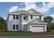 Two-story home showcasing coastal architectural style, a 2-car garage and lush landscaping at 17013 Savory Mist Cir, Lakewood Ranch, FL 34211