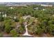 Expansive aerial view of a private home nestled among dense trees and a glistening blue pool at 233 Snyder Dr, Venice, FL 34292