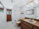 Cozy bathroom featuring neutral colors, a vanity, and a door to an outdoor shower area at 233 Snyder Dr, Venice, FL 34292