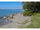 Serene beach with rock seawall and lush green foliage, offering a peaceful escape to the water at 233 Snyder Dr, Venice, FL 34292