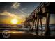 Scenic sunset view of a fishing pier with waves crashing on the beach at 233 Snyder Dr, Venice, FL 34292