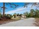 Exterior shot of a distinctive home featuring a stone facade and mature palm trees at 233 Snyder Dr, Venice, FL 34292