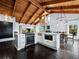 Kitchen features island, modern appliances, dark wood floors, vaulted ceilings, and stone accent wall at 233 Snyder Dr, Venice, FL 34292