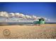 Charming light-green lifeguard stand on the beach with blue sky and ocean views at 233 Snyder Dr, Venice, FL 34292