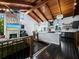 Living area and kitchen combination with wood floors, beamed ceilings, and island seating at 233 Snyder Dr, Venice, FL 34292