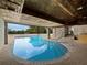 Indoor swimming pool with wood ceiling, stone accent wall and a seamless transition to the outdoors at 233 Snyder Dr, Venice, FL 34292