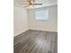 Bright, empty bedroom featuring modern gray wood flooring and a ceiling fan at 4934 Avery Rd, New Port Richey, FL 34652
