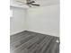 Bright, empty bedroom featuring modern gray wood flooring and a ceiling fan at 4934 Avery Rd, New Port Richey, FL 34652
