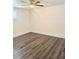Bright, empty bedroom featuring modern gray wood flooring and a ceiling fan at 4934 Avery Rd, New Port Richey, FL 34652