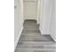 Hallway with modern gray wood flooring leading to a set of bright white double doors at 4934 Avery Rd, New Port Richey, FL 34652
