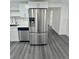 Kitchen displays stainless steel refrigerator and dishwasher, white cabinets, and light gray vinyl flooring at 4934 Avery Rd, New Port Richey, FL 34652