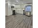 Well-lit kitchen showcases stainless appliances, white cabinetry, and modern gray vinyl flooring at 4934 Avery Rd, New Port Richey, FL 34652