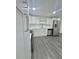 Bright kitchen featuring white cabinets, stainless steel appliances, and modern gray flooring at 4934 Avery Rd, New Port Richey, FL 34652