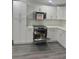 Kitchen features stainless steel oven, microwave, white cabinets and subway tile backsplash at 4934 Avery Rd, New Port Richey, FL 34652