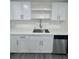 Kitchen with stainless steel appliances, modern white cabinets and gray flooring at 4934 Avery Rd, New Port Richey, FL 34652