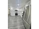 Bright kitchen view featuring modern stainless steel appliances and white cabinets, with gray vinyl flooring at 4934 Avery Rd, New Port Richey, FL 34652