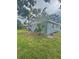 A view of the side yard and the side of the home with some green space at 4934 Avery Rd, New Port Richey, FL 34652