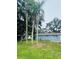 A view of the side of the home with a healthy green lawn and mature palm trees at 4934 Avery Rd, New Port Richey, FL 34652