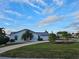 White single story home with palm trees and a driveway at 975 Coronado Dr, Punta Gorda, FL 33950